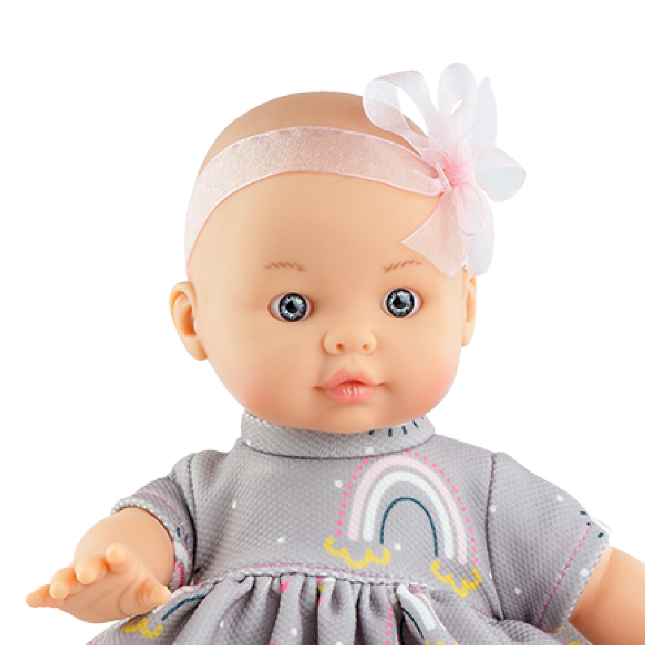 Baby doll wearing a gray dress with rainbow patterns on a white background