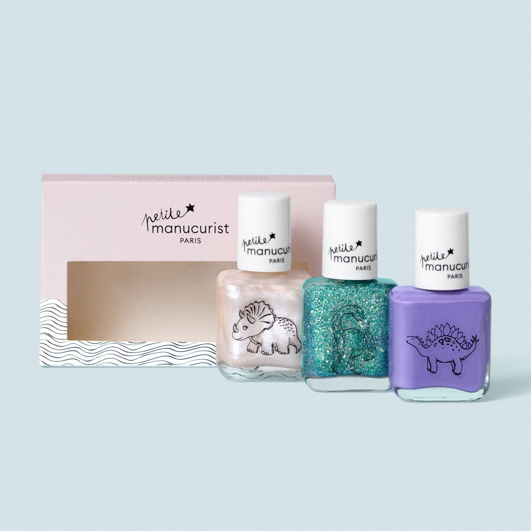 Set of four nail polish bottles with a pink packaging box on a light blue background