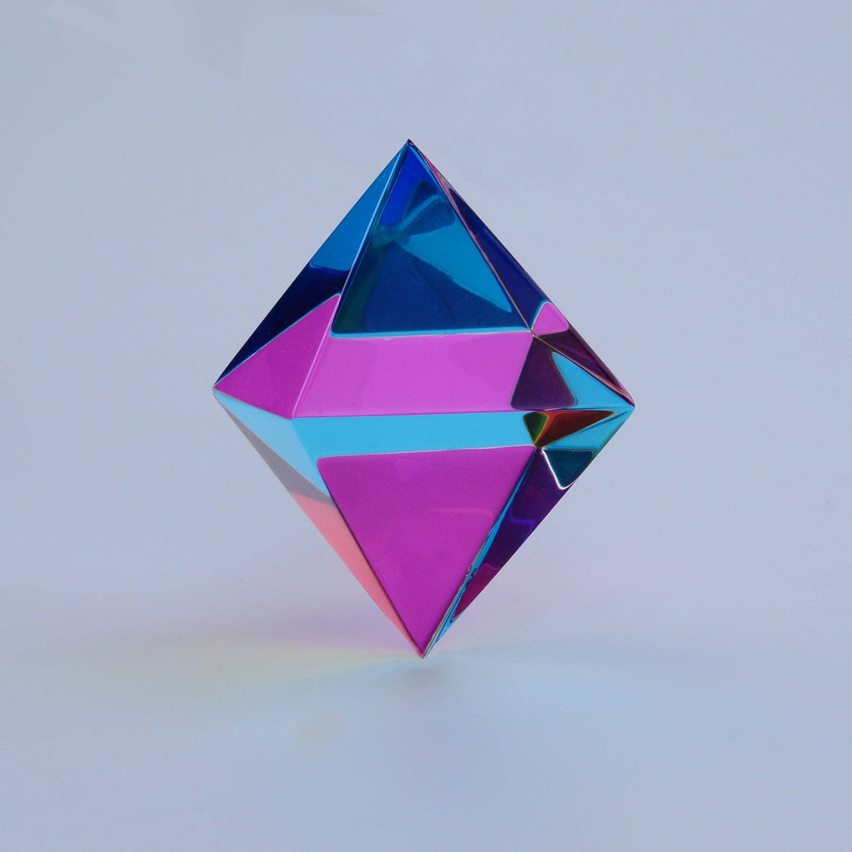 Multicolored geometric prism on a light gray background