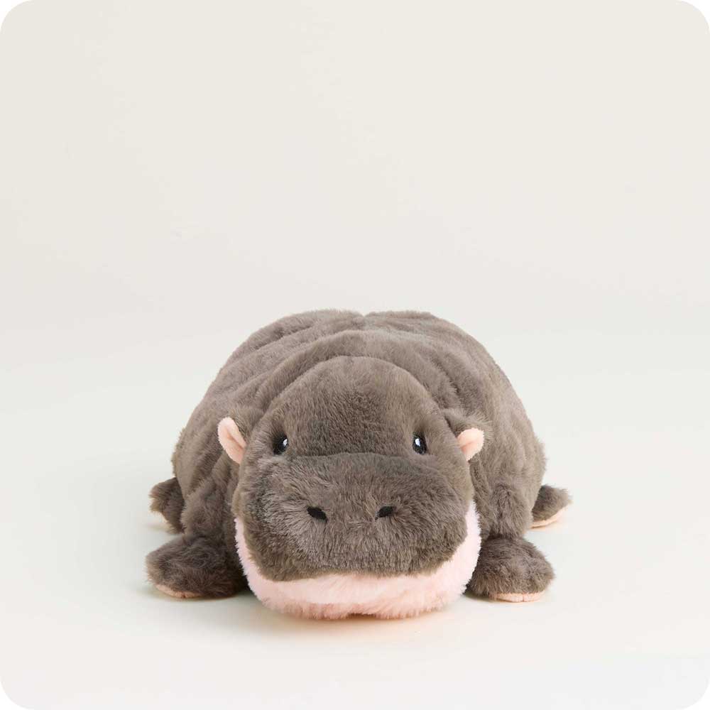 A plush hippopotamus toy lying down, featuring dark gray plush fur, small pink inner ears, and a soft pink under-chin and mouth area, set against a plain off-white background.