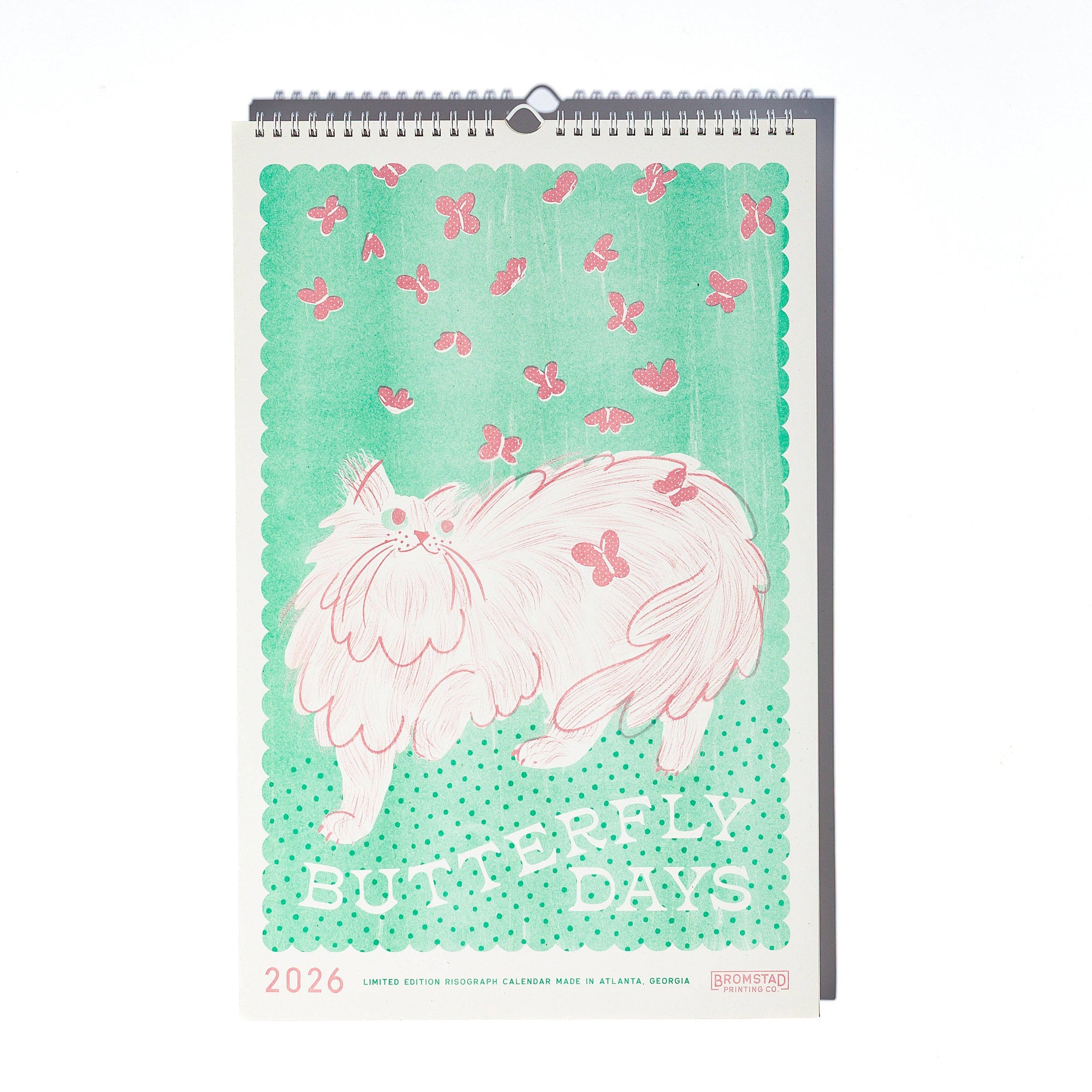 Calendar with a cat illustration and butterfly design on a green background