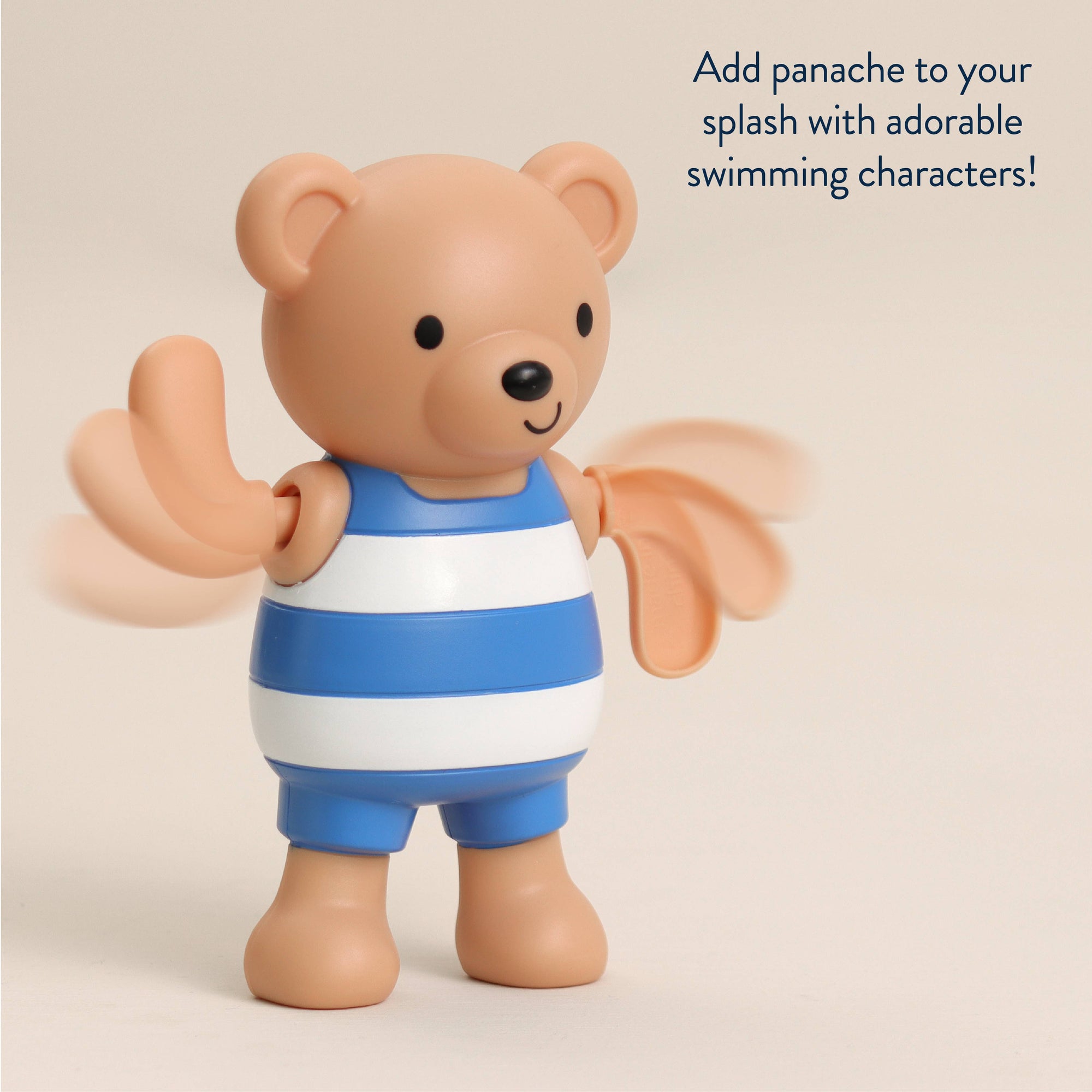 Toy bear in a blue and white striped swimsuit on a beige background