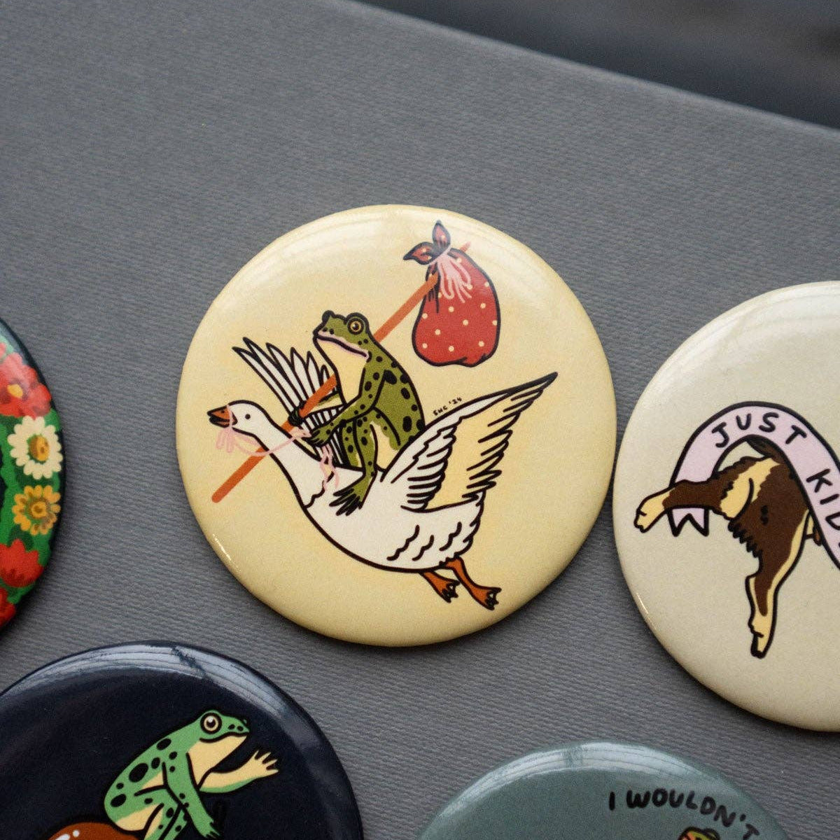 Collection of colorful buttons with various designs on a gray surface