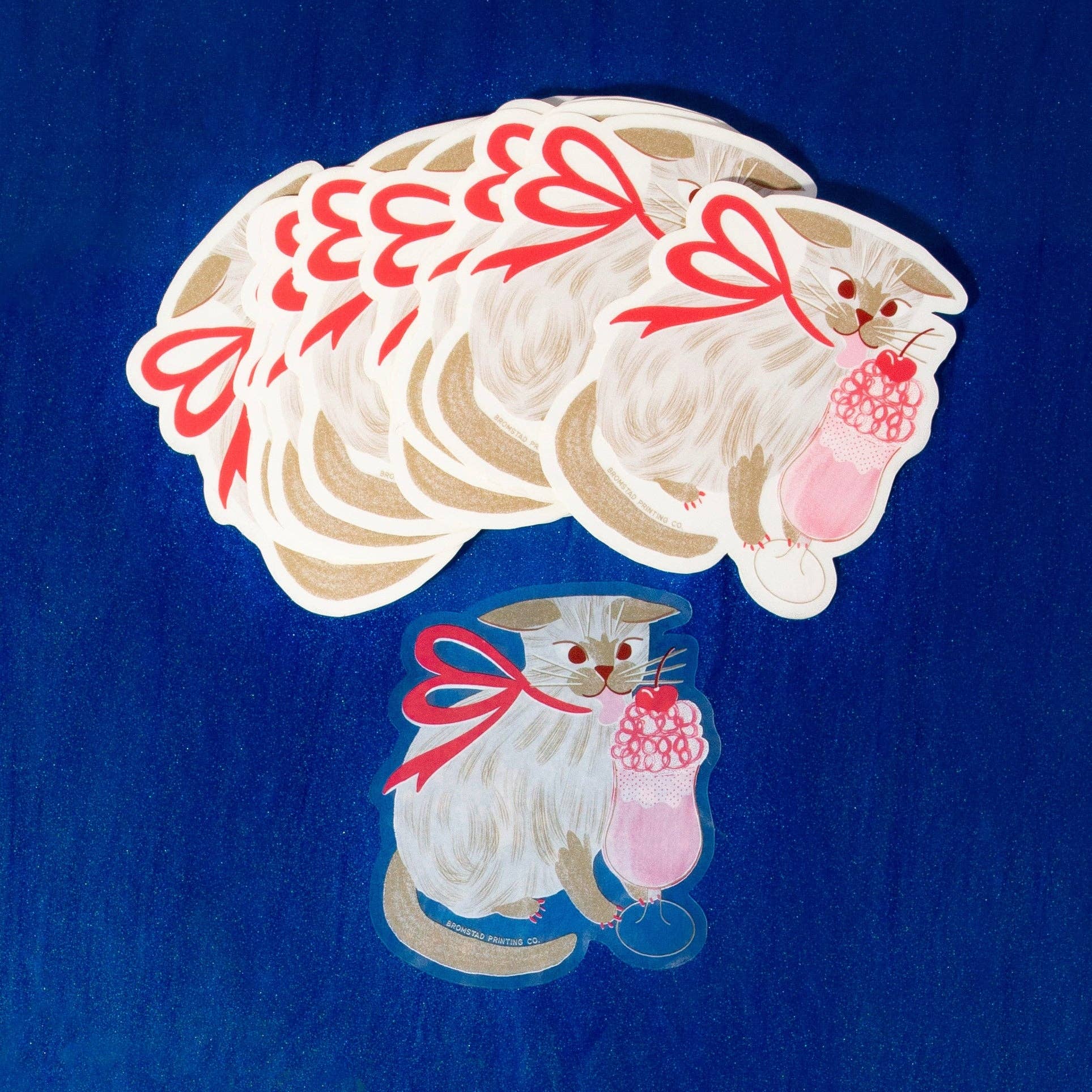 Illustration of a cat holding a pink drink with red bows on a blue background