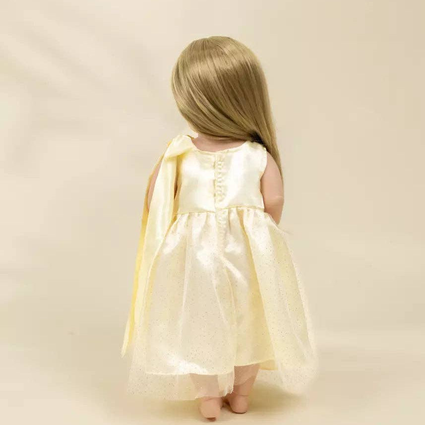 doll in a white dress with a yellow cape on a beige background