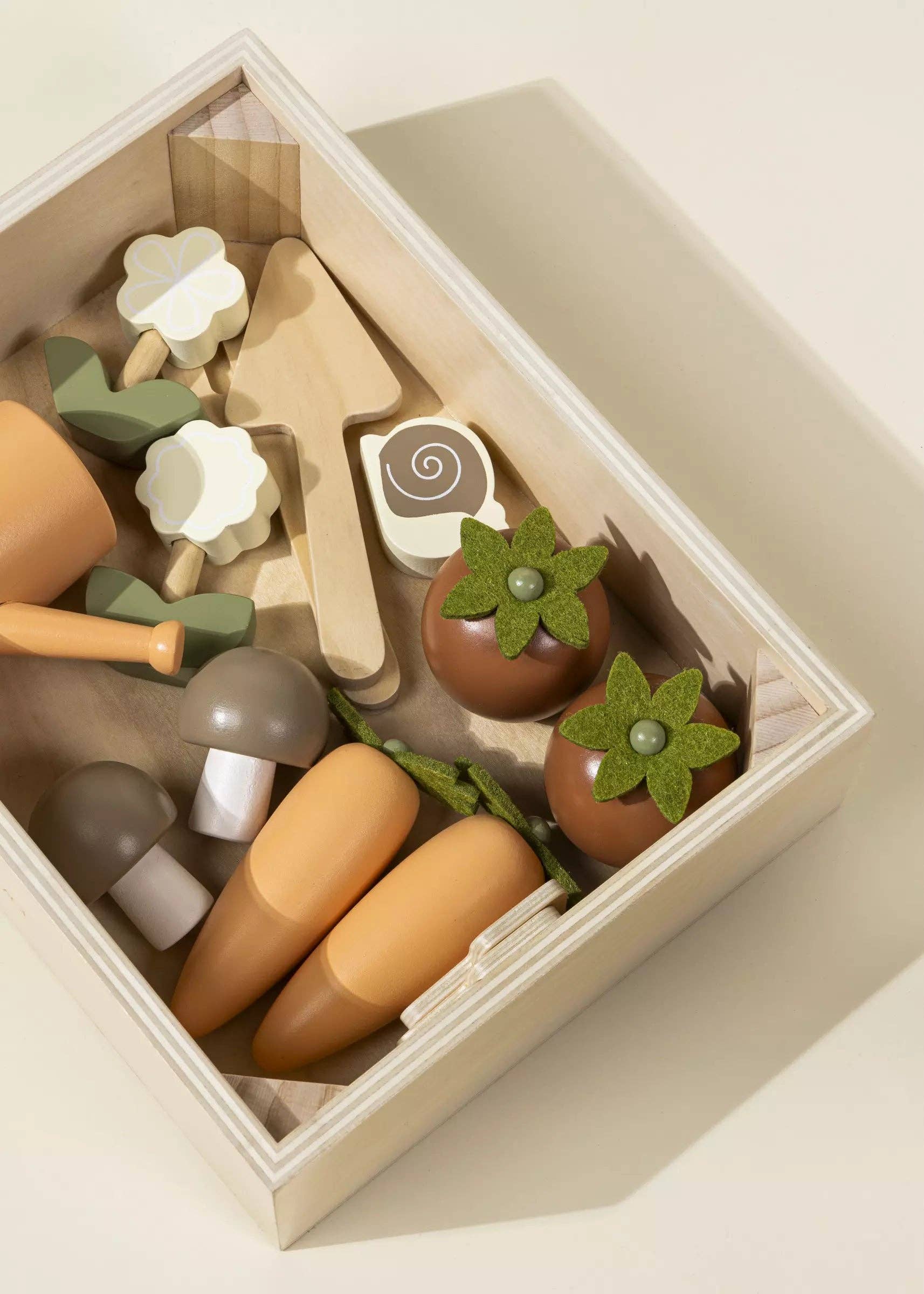 Set of wooden toys in a box with various shapes and colors on a light background