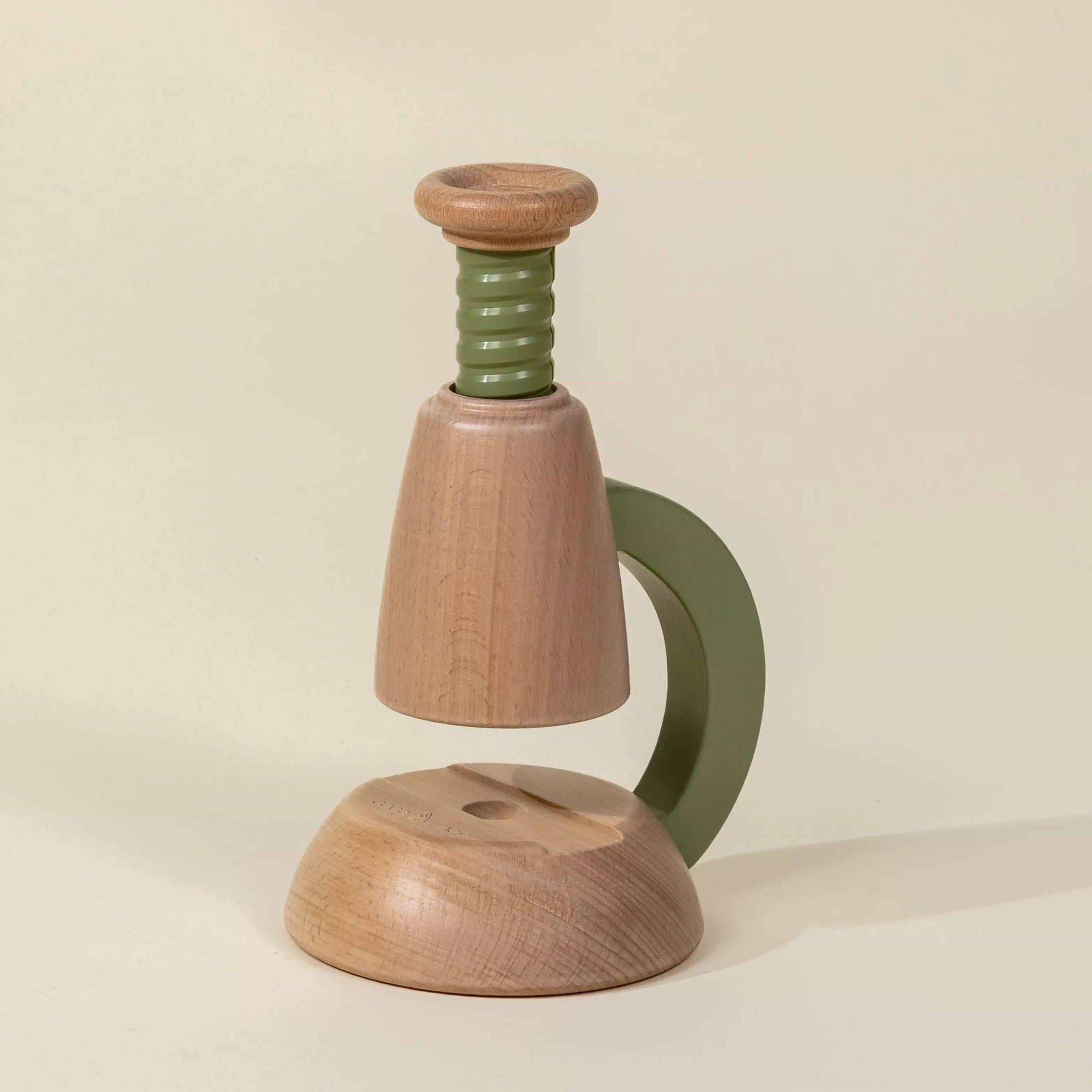Wooden and green object on a beige background