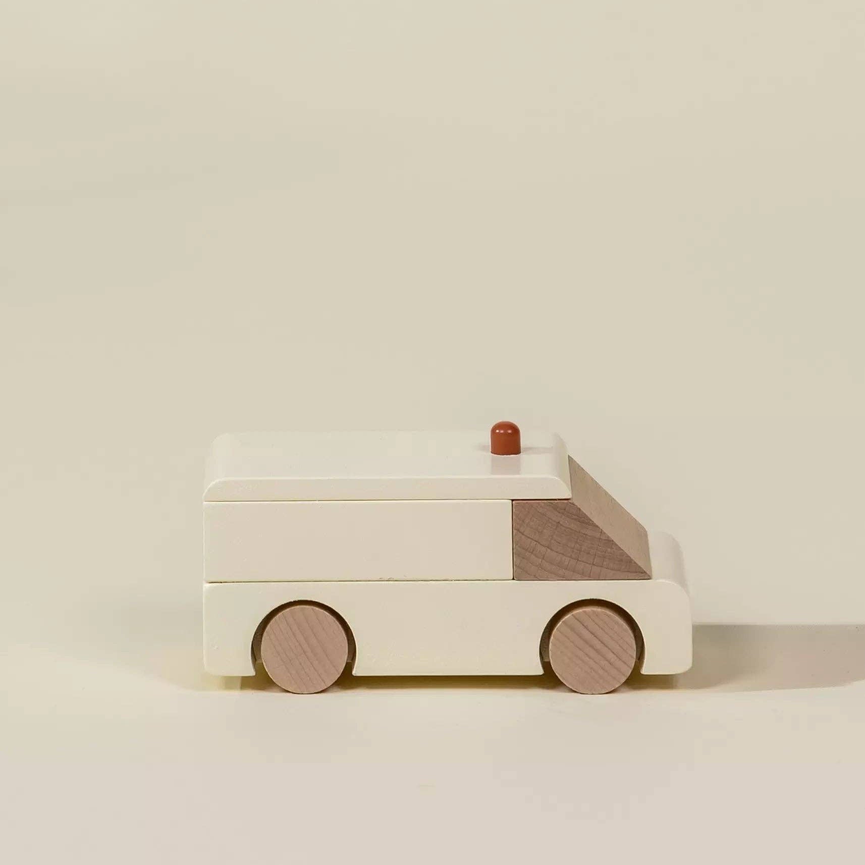 Wooden toy ambulance on a beige background