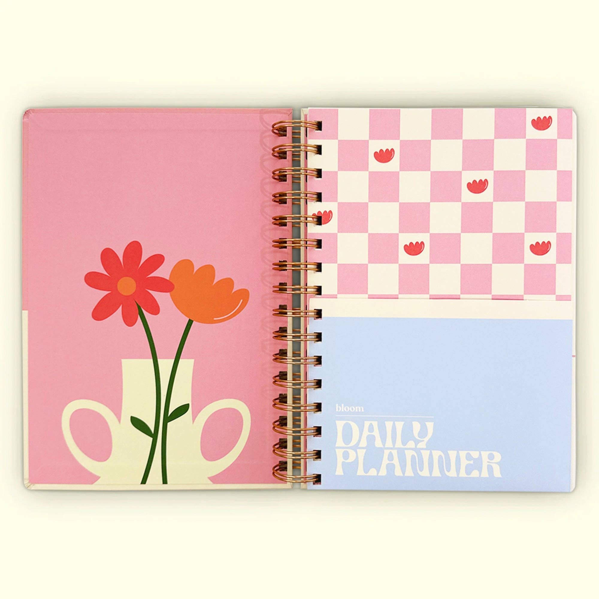 Spiral-bound planner with floral design on pink cover and checkered pattern on blue page