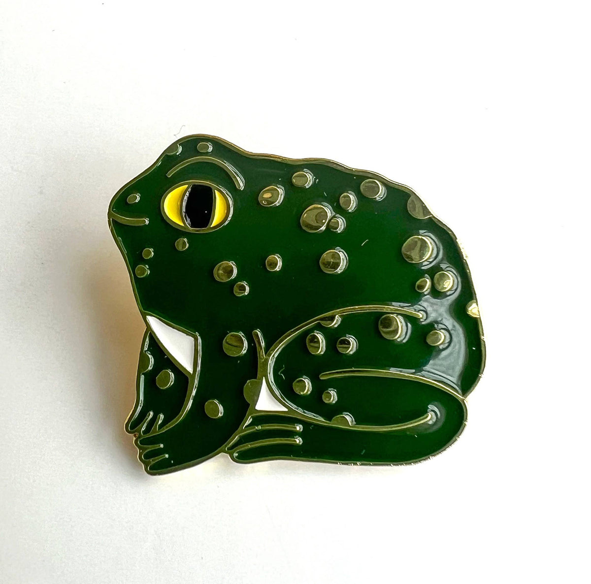 Green frog-shaped enamel pin on a white background
