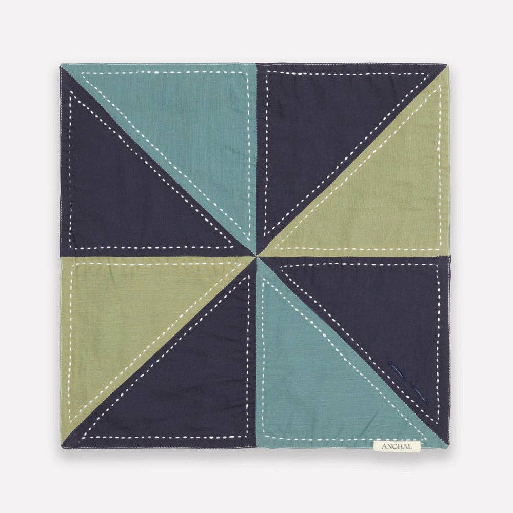 Fabric square with a geometric pattern in navy, green, and teal on a white background