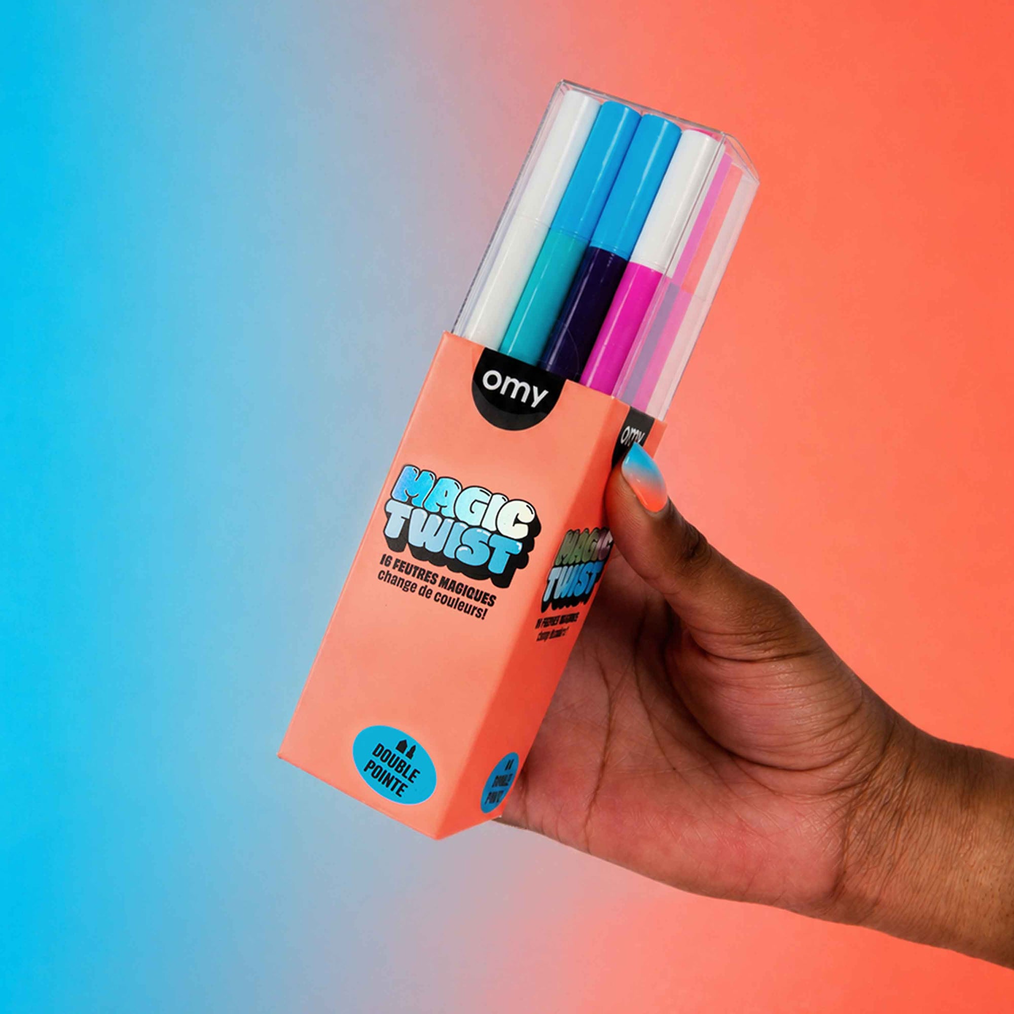 Hand holding a pack of colorful markers with 'magic twist' packaging against a gradient background