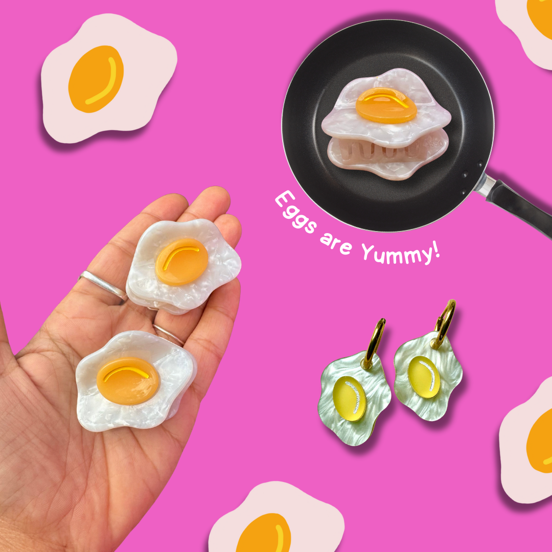 Egg-shaped earrings on a pink background with text 'Eggs are Yummy!'