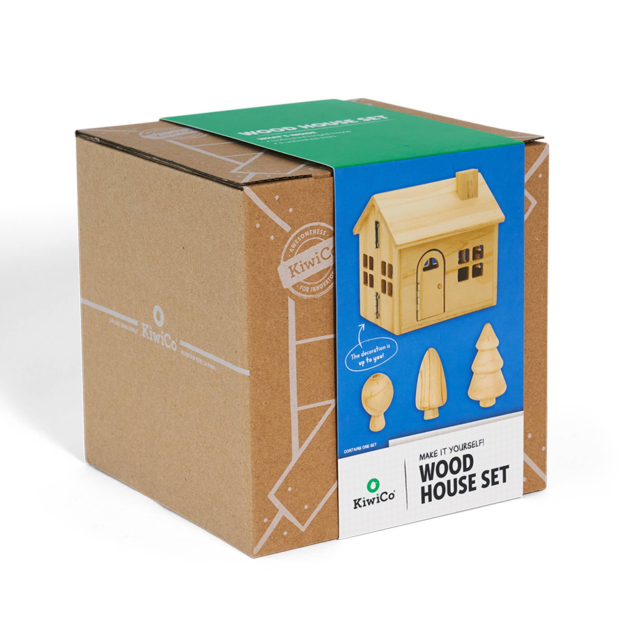 KiwiCo wooden house set in its original brown cardboard packaging box, featuring a blue label with an illustration of the assembled wooden house.