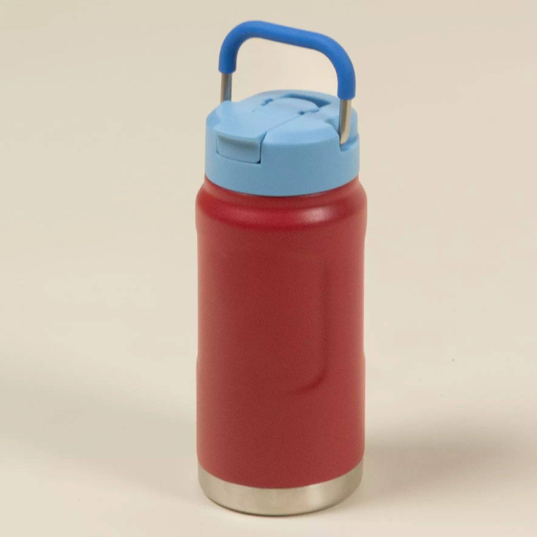 Red water bottle with a blue lid on a beige background