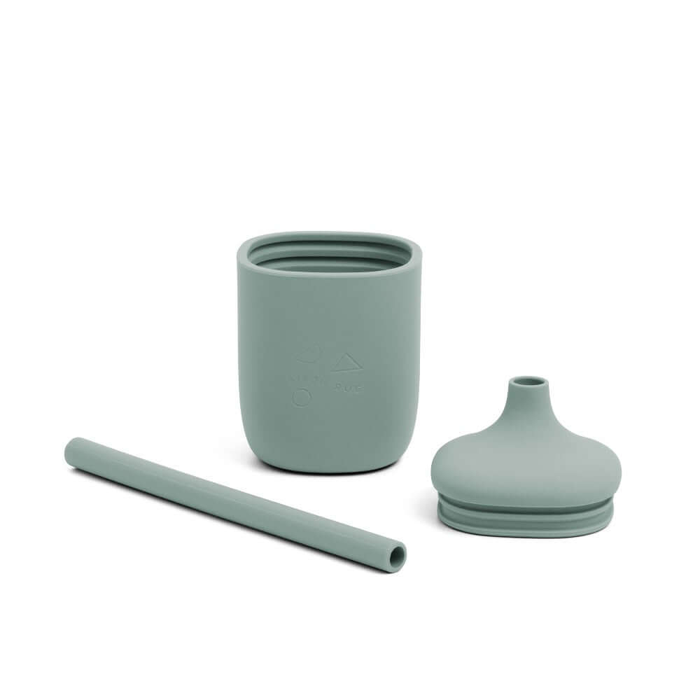 Set of green sippie cup, straw, and lid on a white background