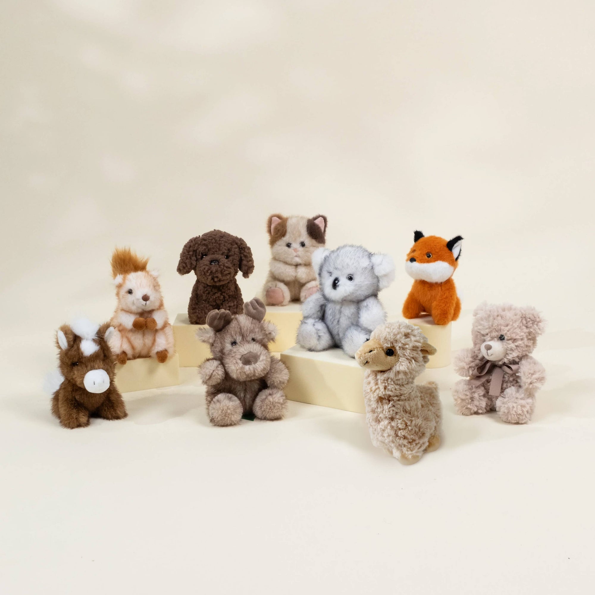 Collection of small stuffed animals on a beige background