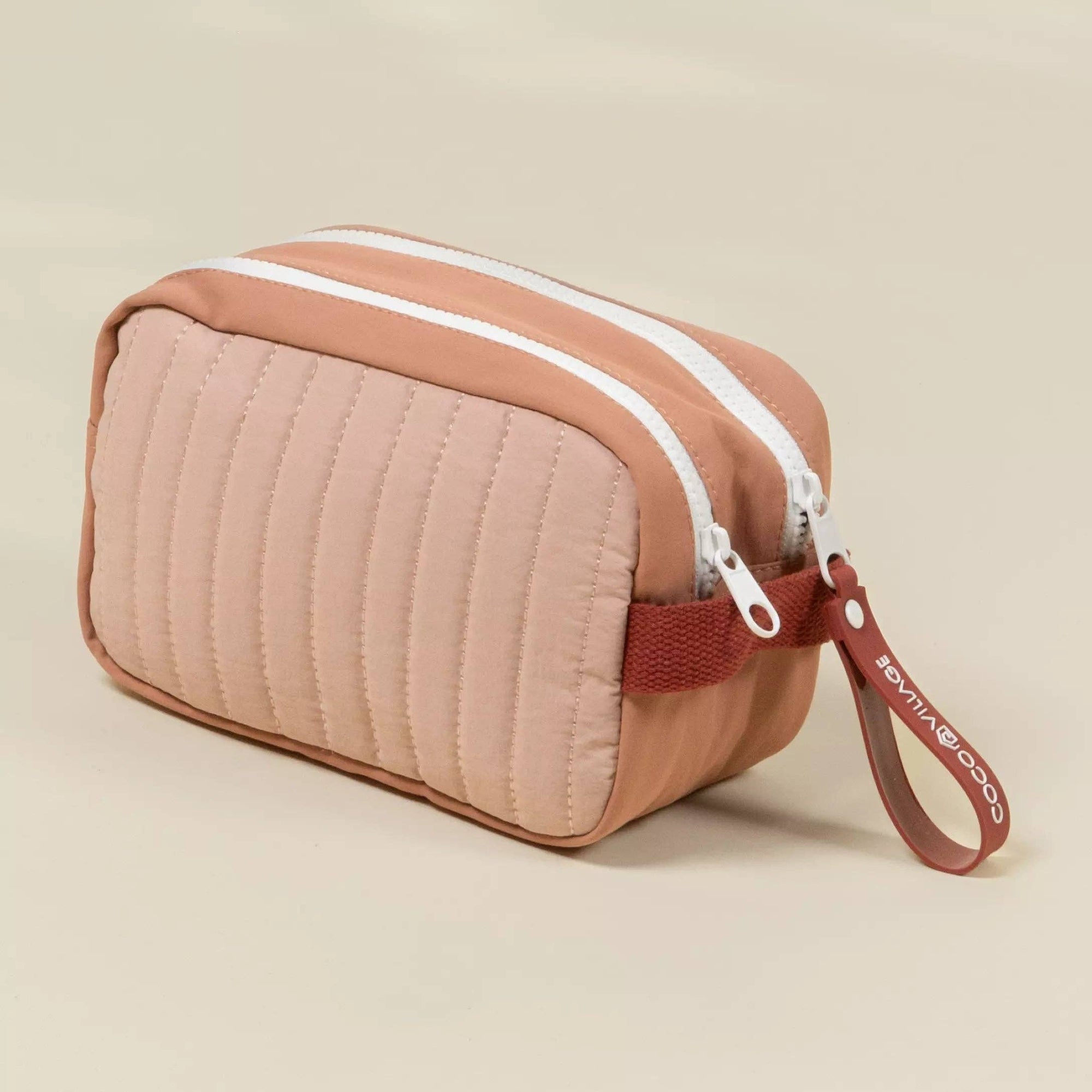 Quilted cosmetic bag with a strap on a beige background