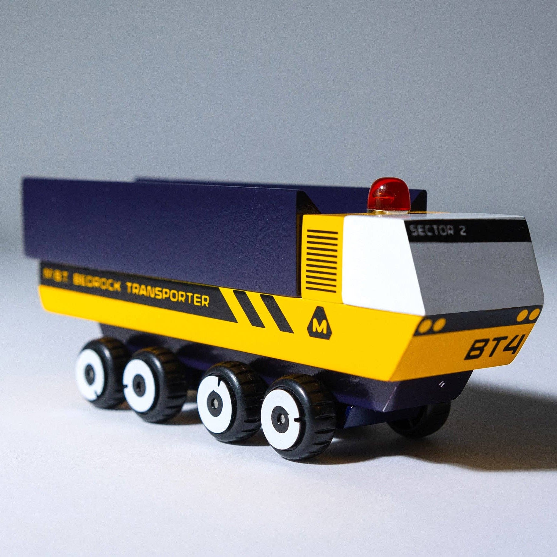 Toy dump truck with blue and yellow colors on a gray background