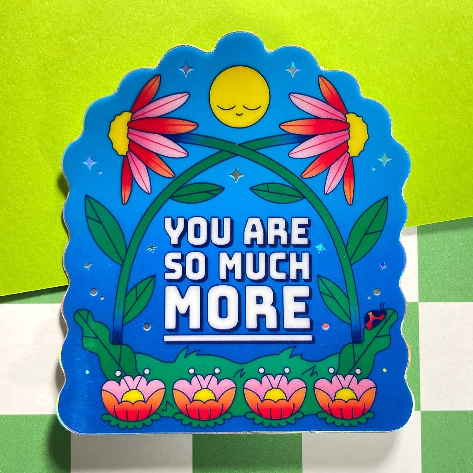Colorful decorative sign with floral design and text on a green and white checkered background