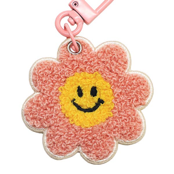 Flower-shaped keychain with a smiley face on a white background