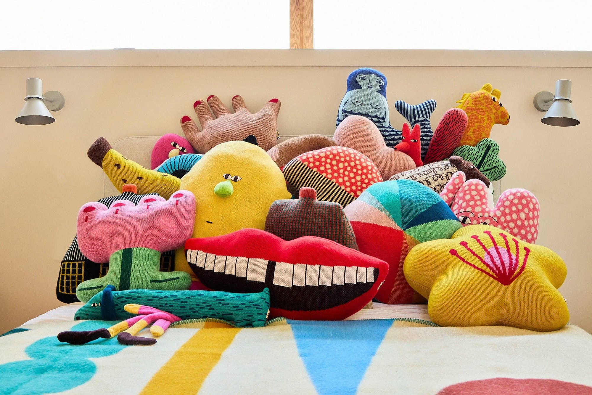 Colorful plush toys on a bed with a striped bedspread