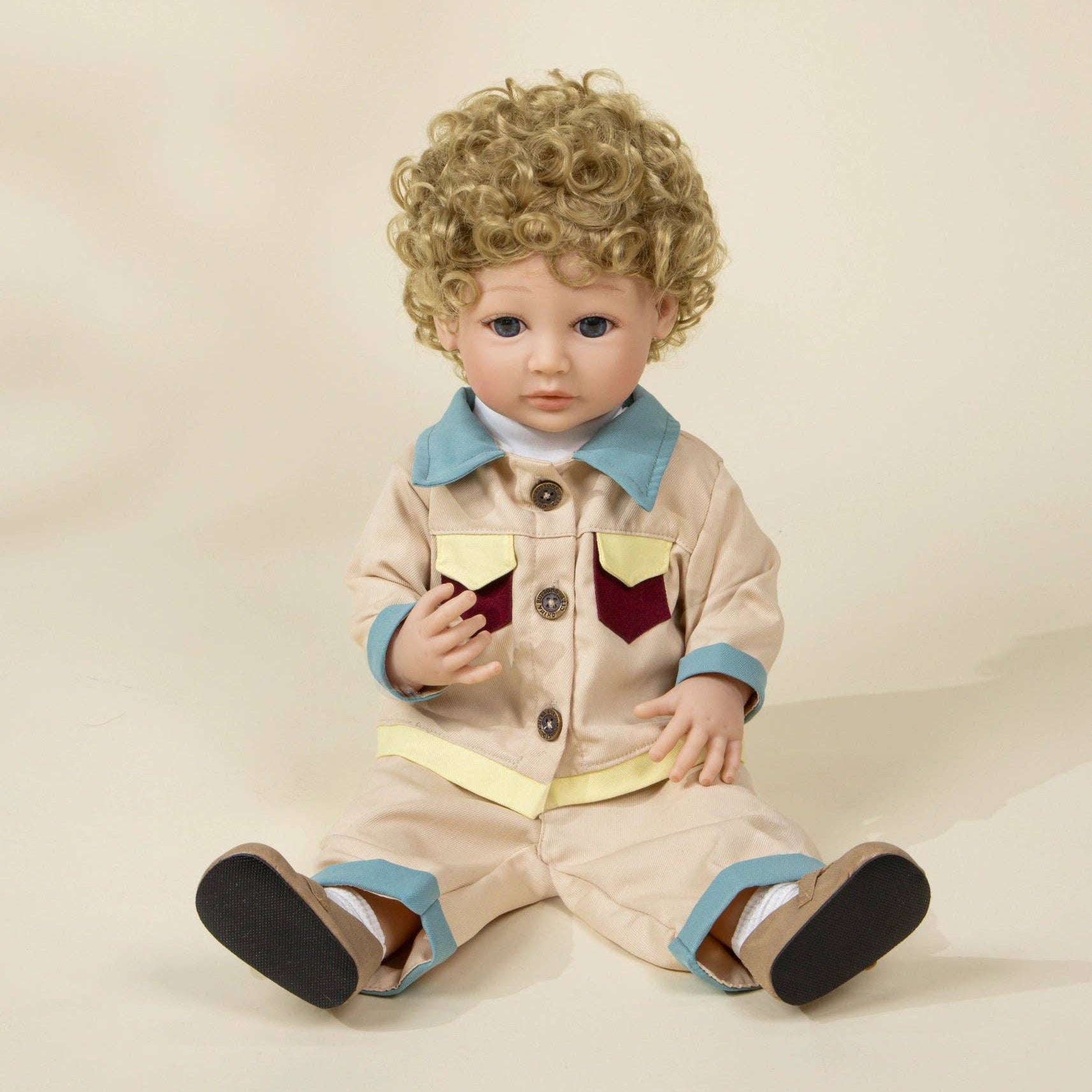 Doll wearing a beige outfit with blue accents on a plain background