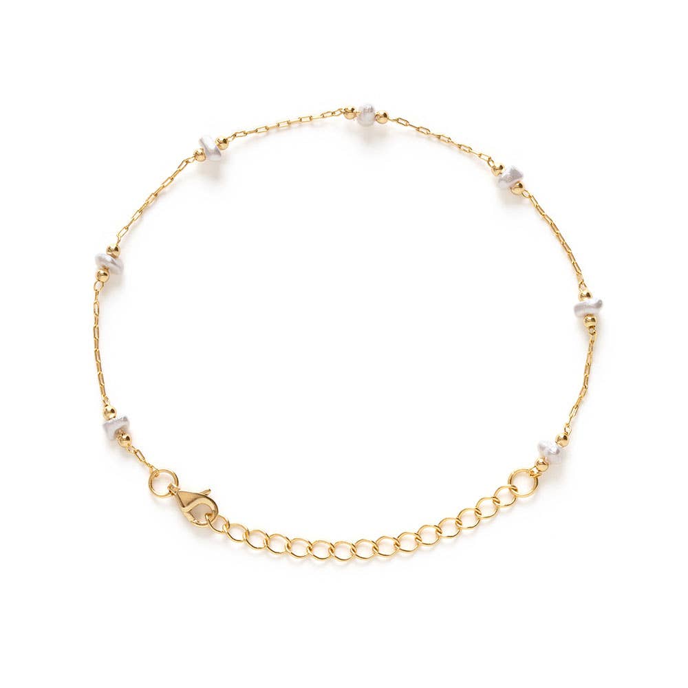 Gold bracelet with small beads on a white background