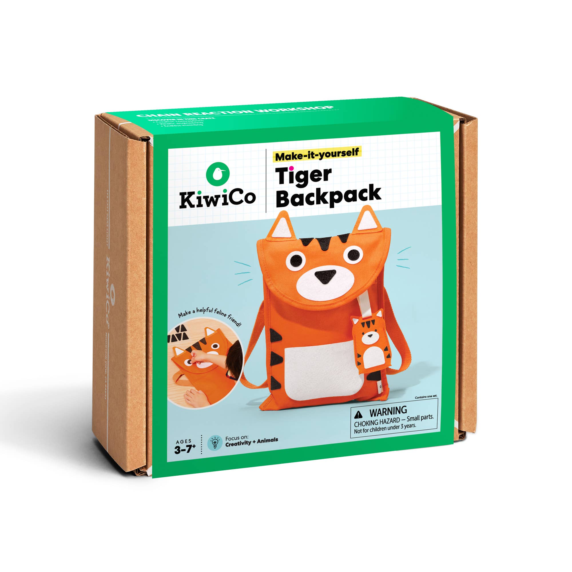 Kiwipro 'Make-it-yourself Tiger Backpack' product box, showing an orange cartoon tiger backpack design on a green and white front panel with brown cardboard sides, photographed on a white background.