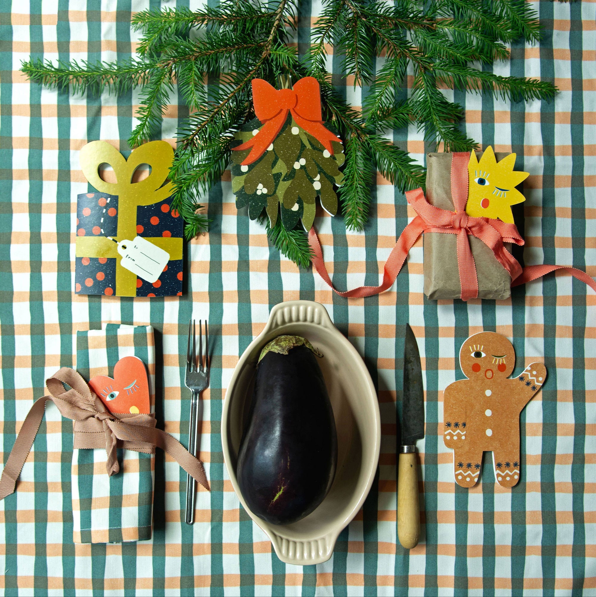 Christmas-themed table setting with decorative items on a striped tablecloth