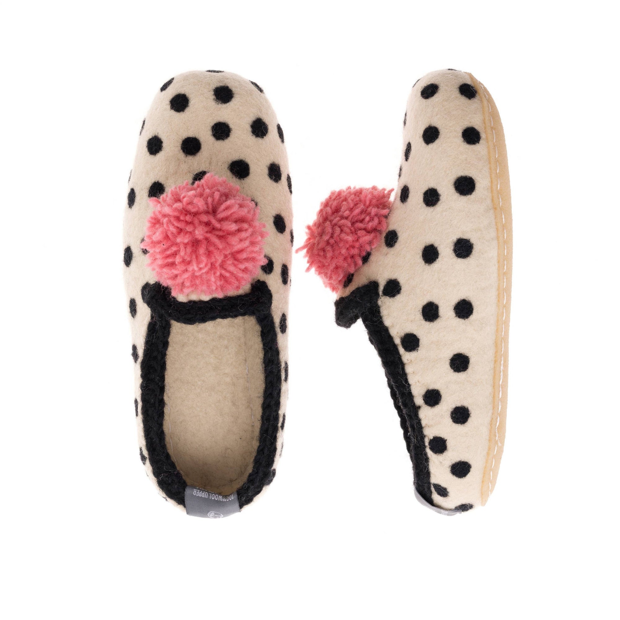 Pair of polka dot slippers with pom-poms on a white background
