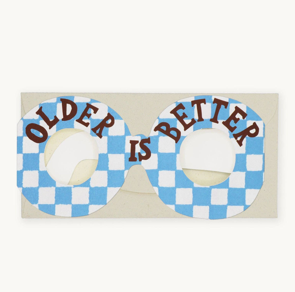 Sunglasses with 'OLDER IS BETTER' text on a blue and white checkered pattern, on a beige background.