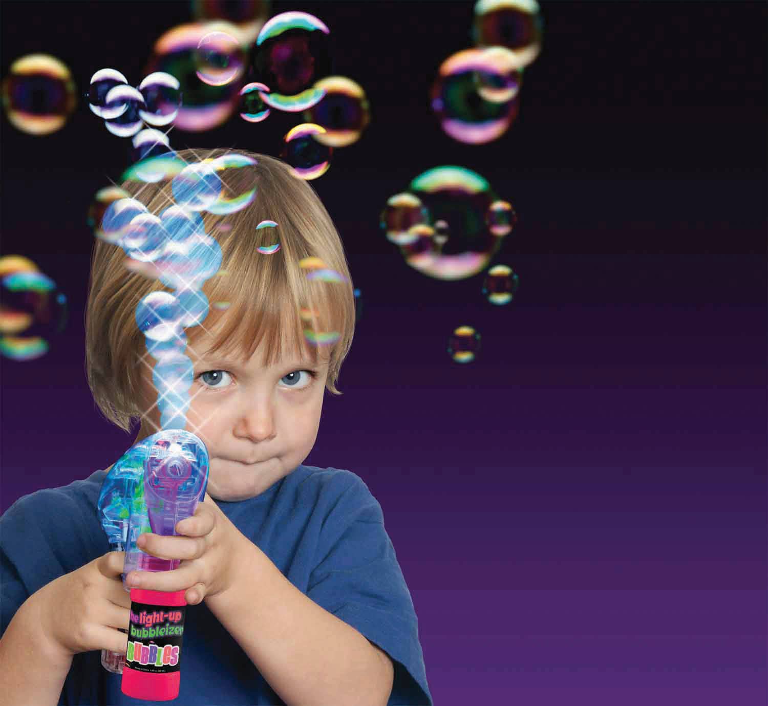 Child holding a bubble wand with colorful bubbles against a dark background