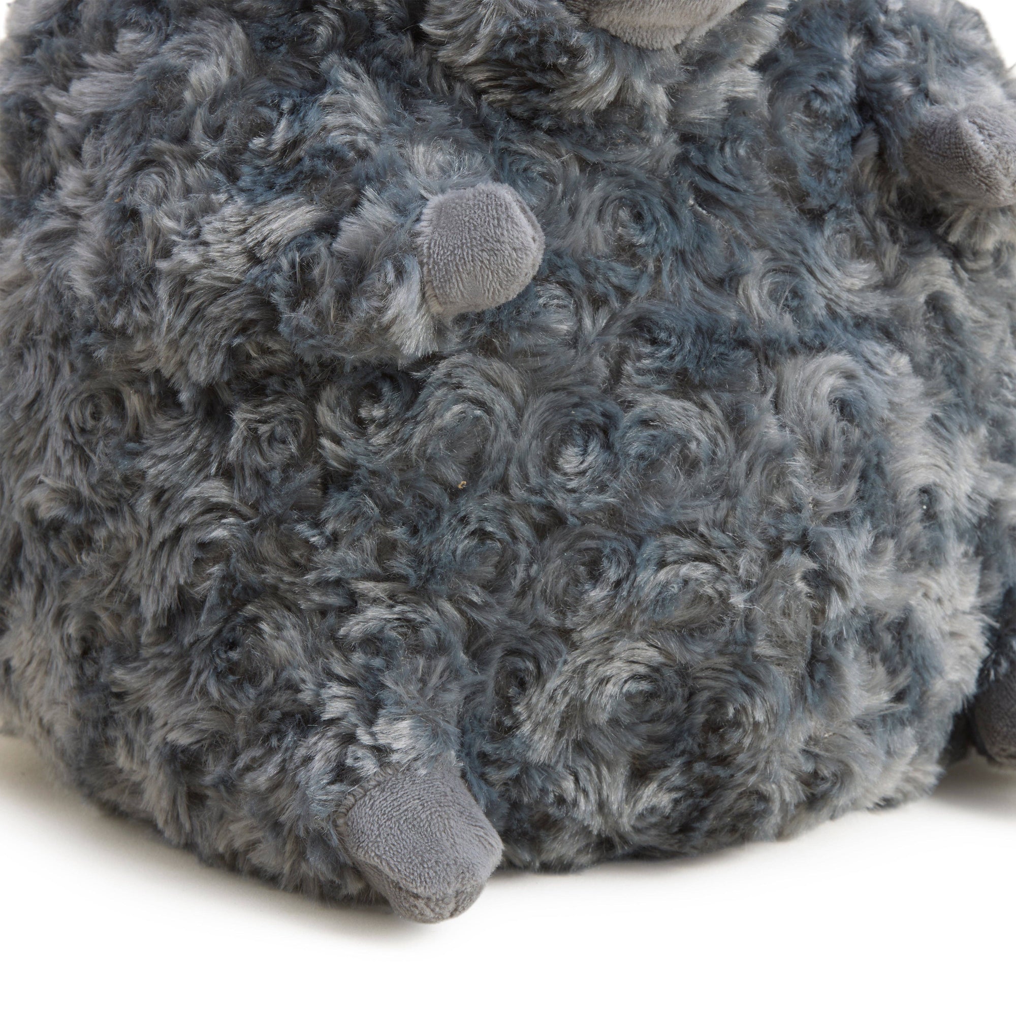 Close-up of a gray plush toy with textured surface on a white background
