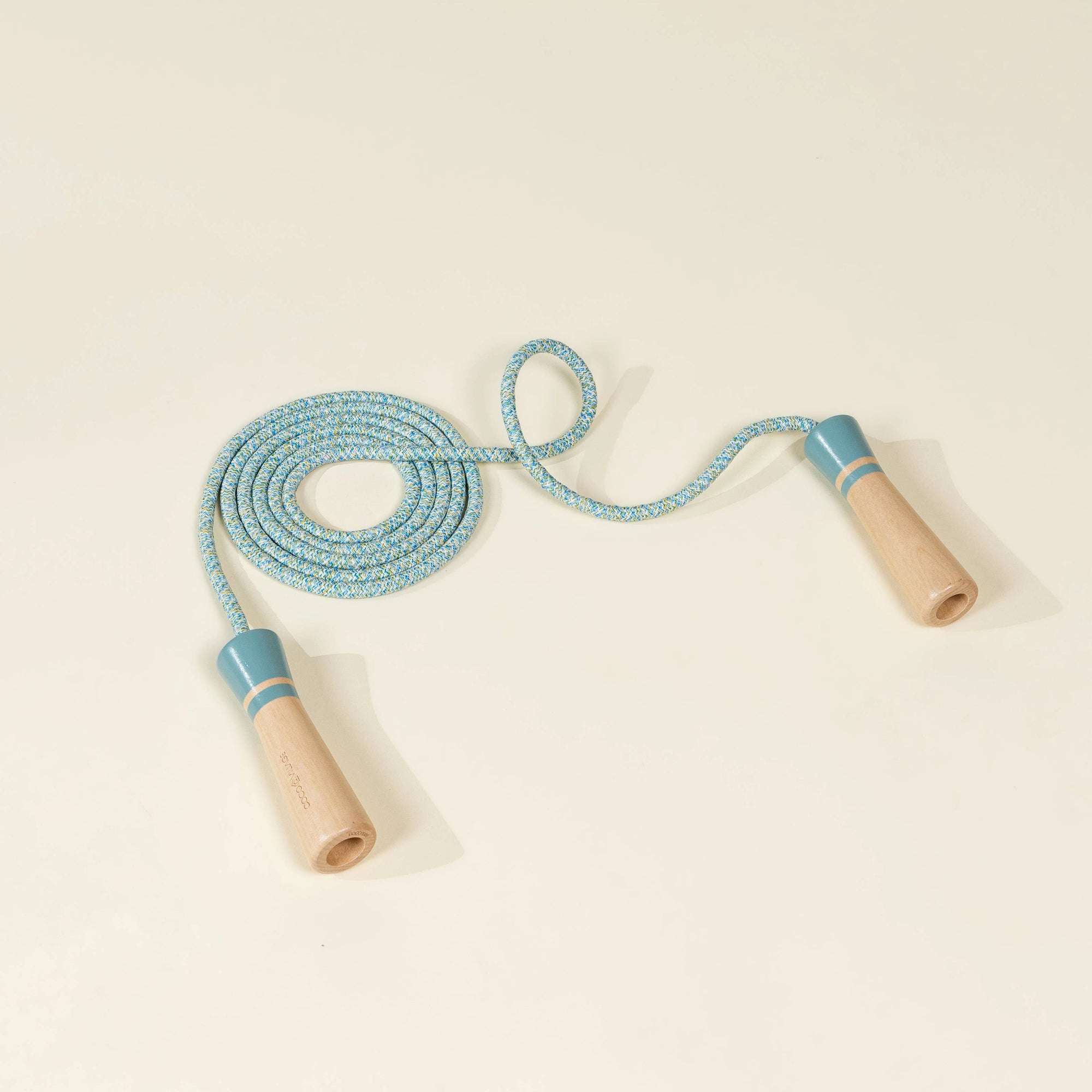 Jump rope with blue rope and wooden handles on a beige background