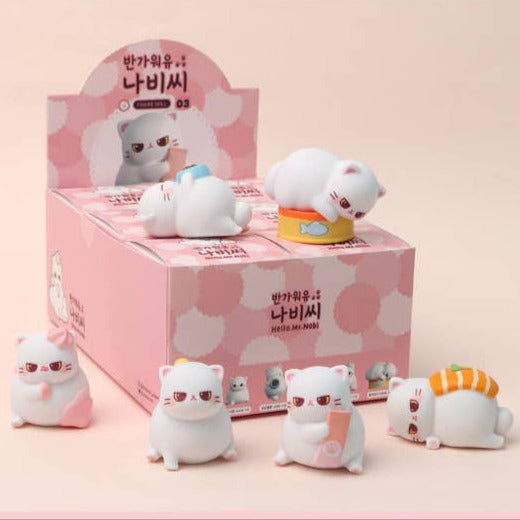 Set of cute cat-shaped figurines with a pink box in the background