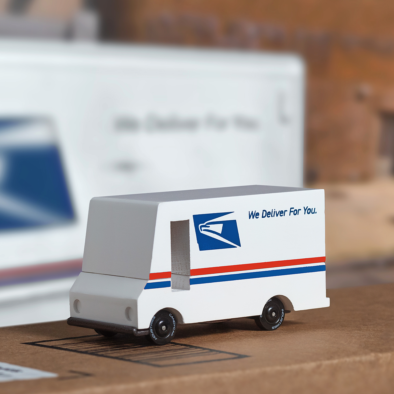 Model of a postal delivery truck with USPS logo on a blurred background