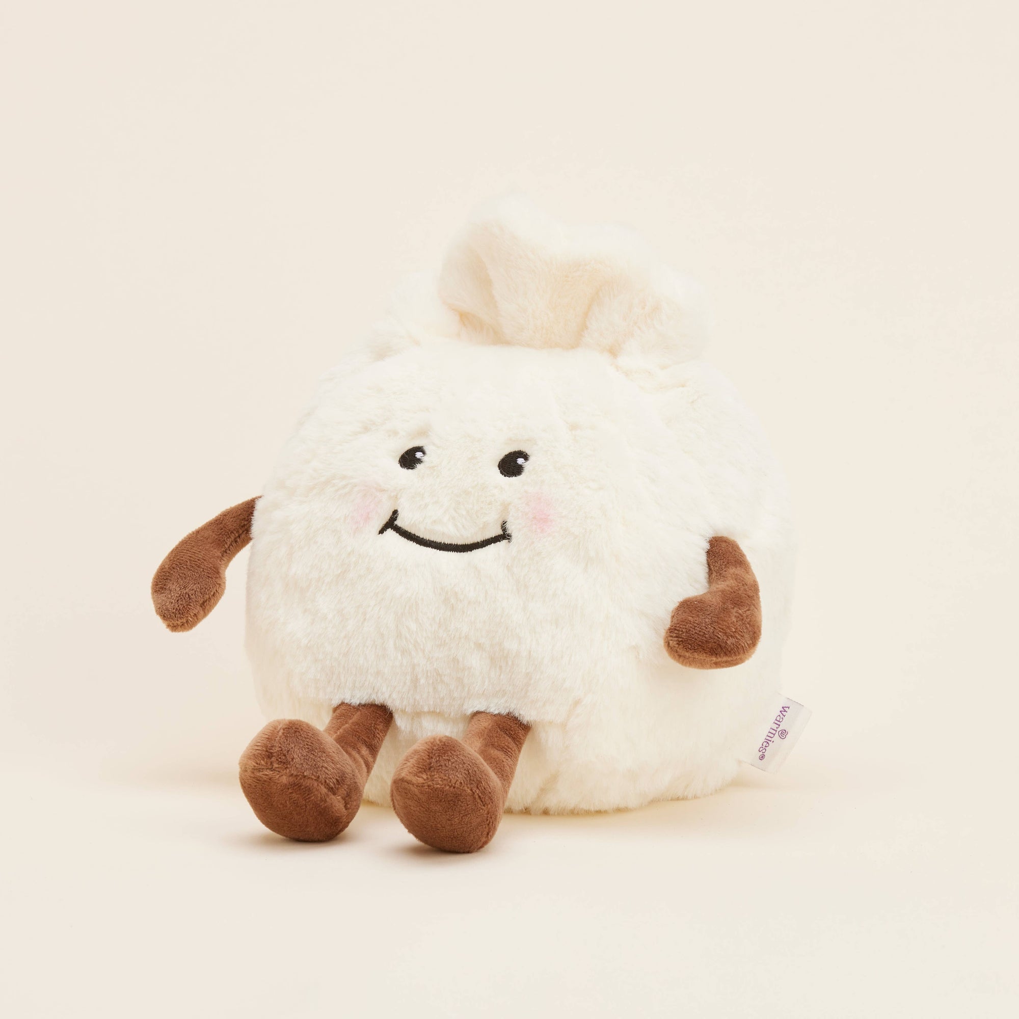 Plush toy dumpling with a happy expression on a beige background