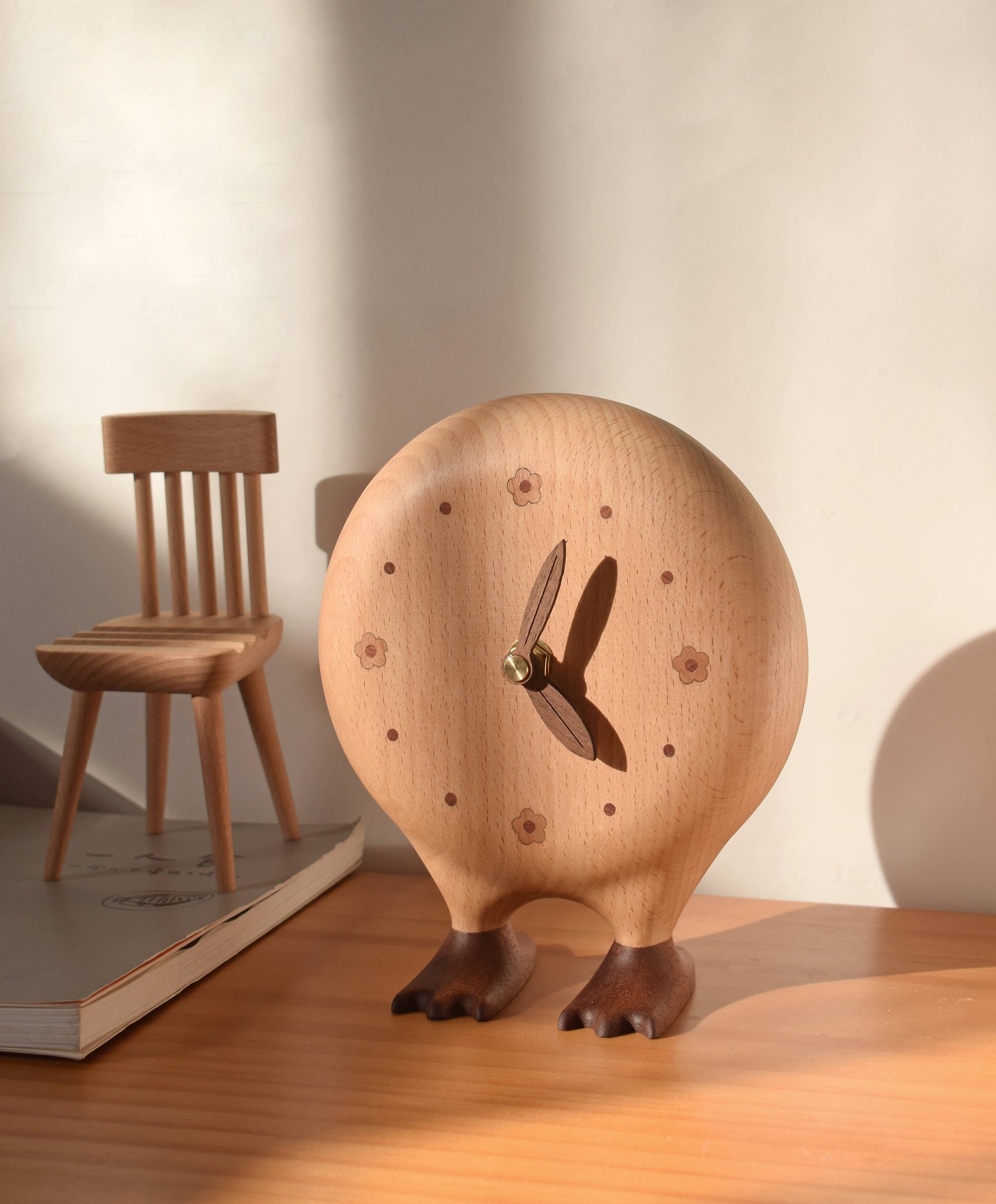 Wooden clock with a chair and book in the background