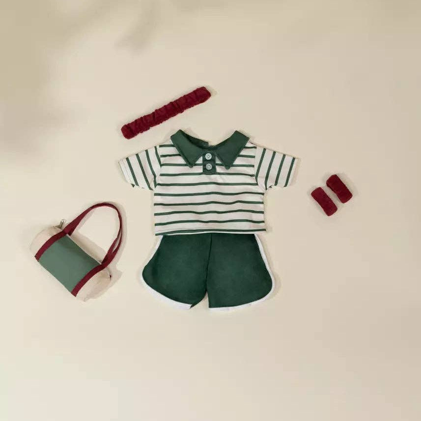 doll outfit with striped shirt, shorts, and accessories on a beige background