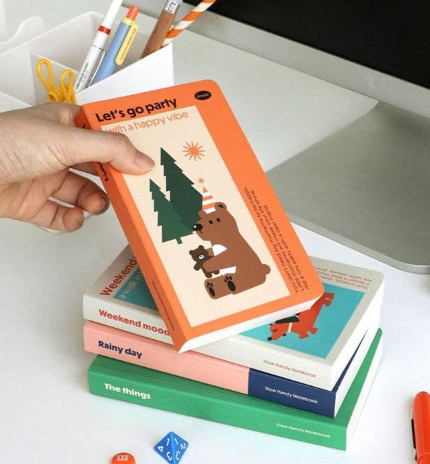 Stack of colorful books with bear illustrations on a white surface