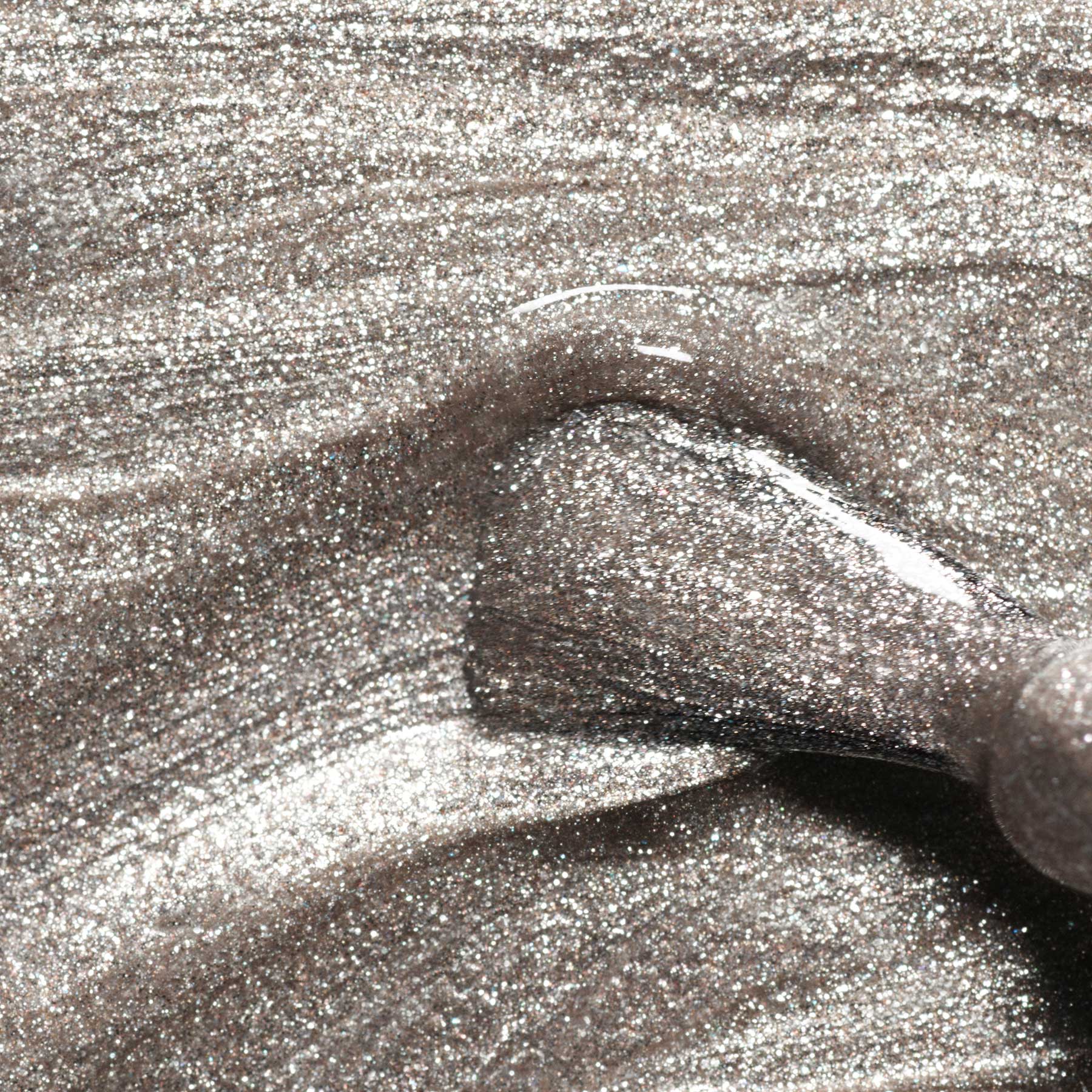 Close-up of silver glittery fabric with a hand holding it