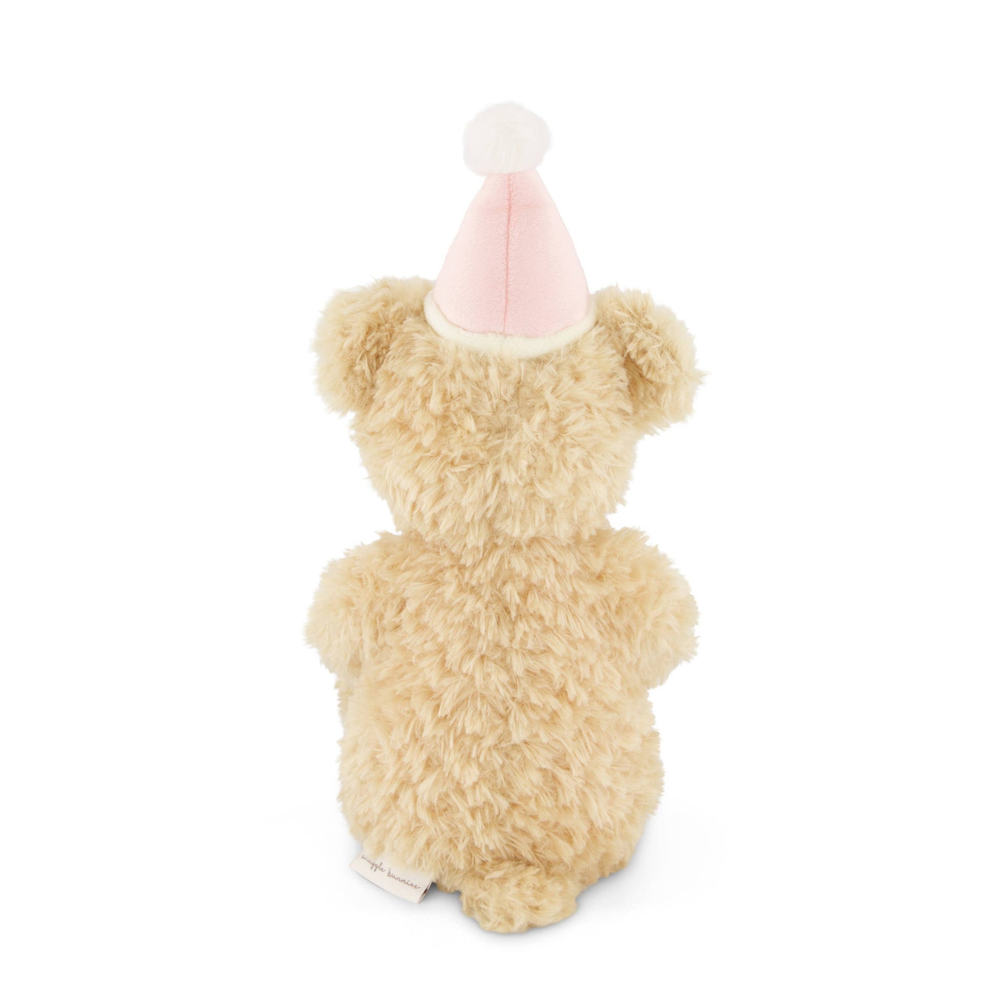 Small teddy bear wearing a pink party hat on a white background
