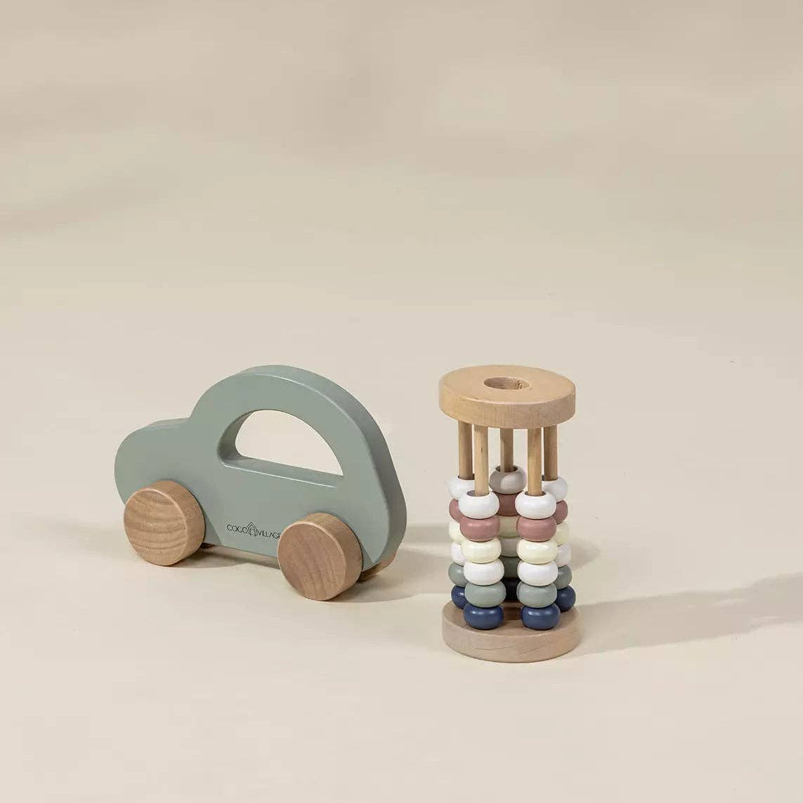 Wooden toy car and beaded tower on a beige background
