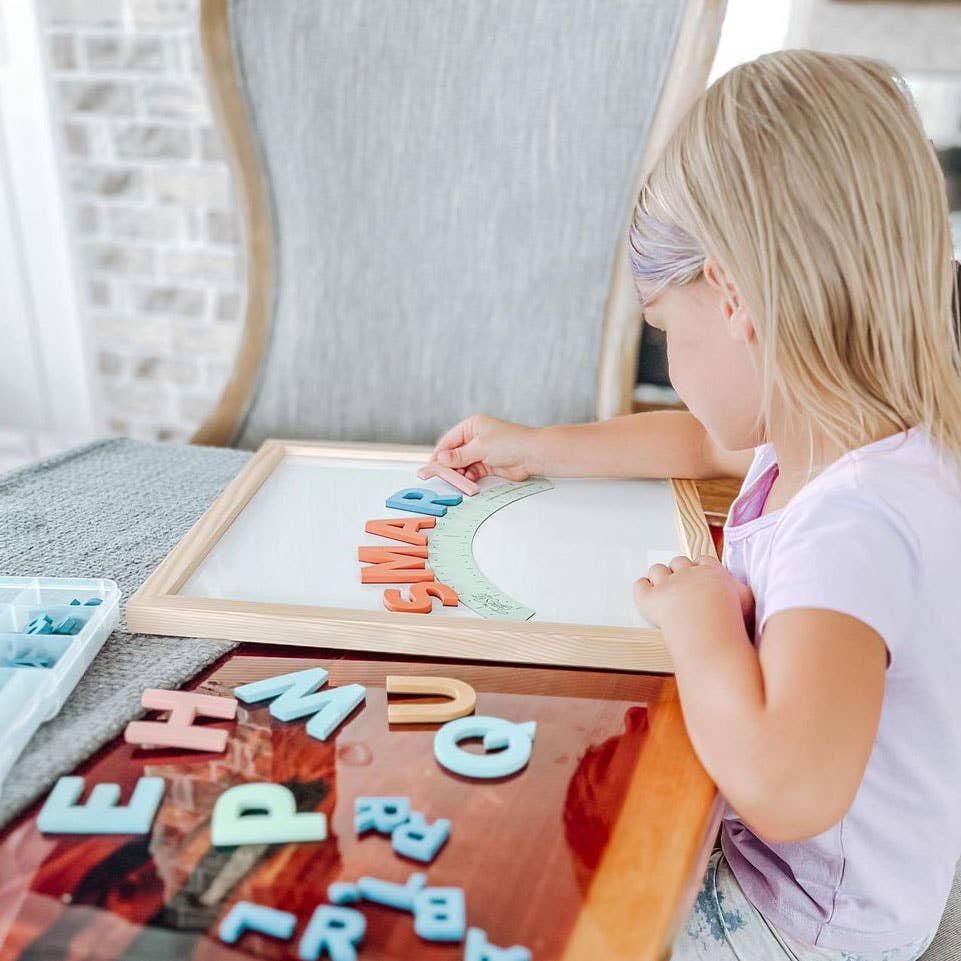 Child playing with magnetic letters on a table