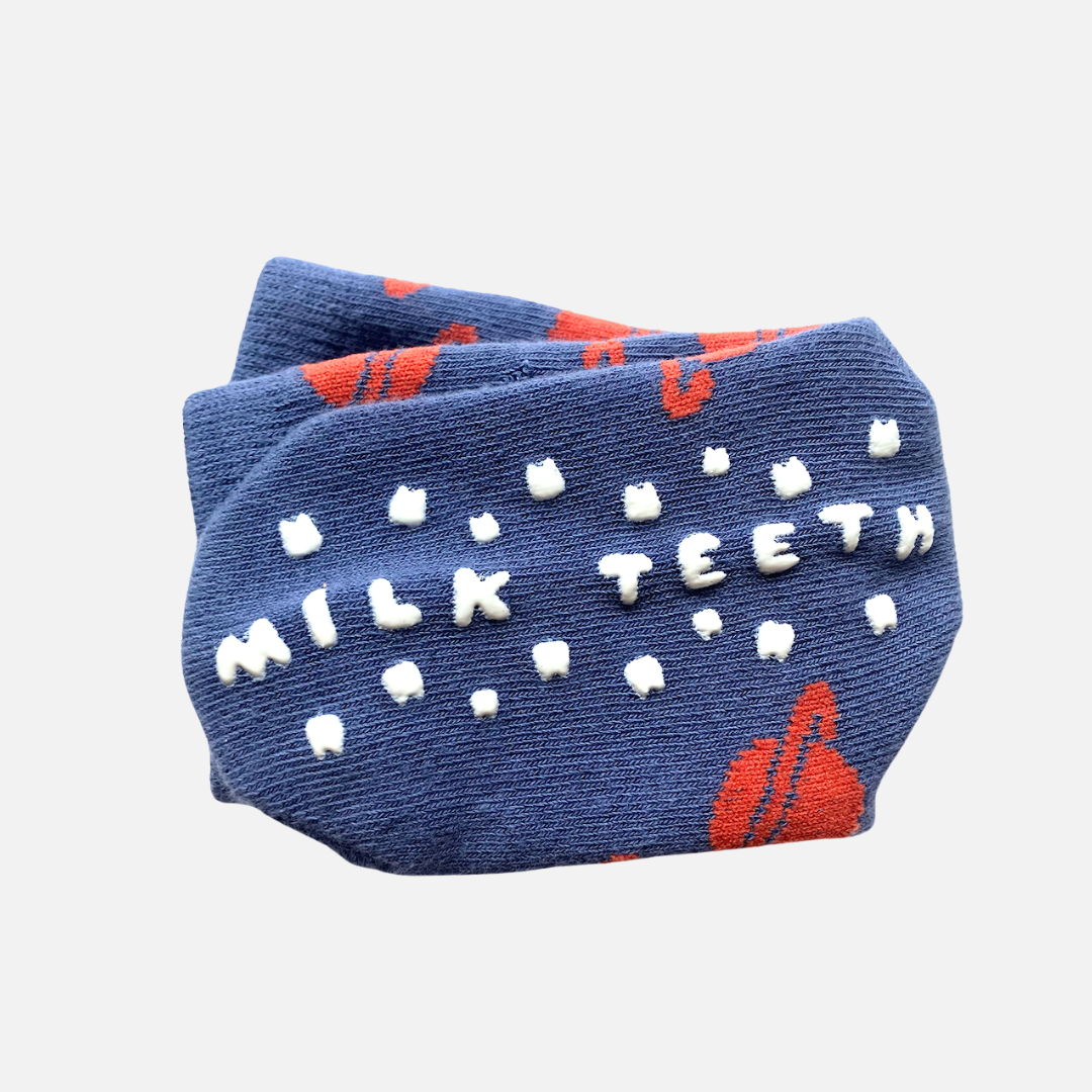 Blue sock with 'Milk Teeth' text and red accents on a white background
