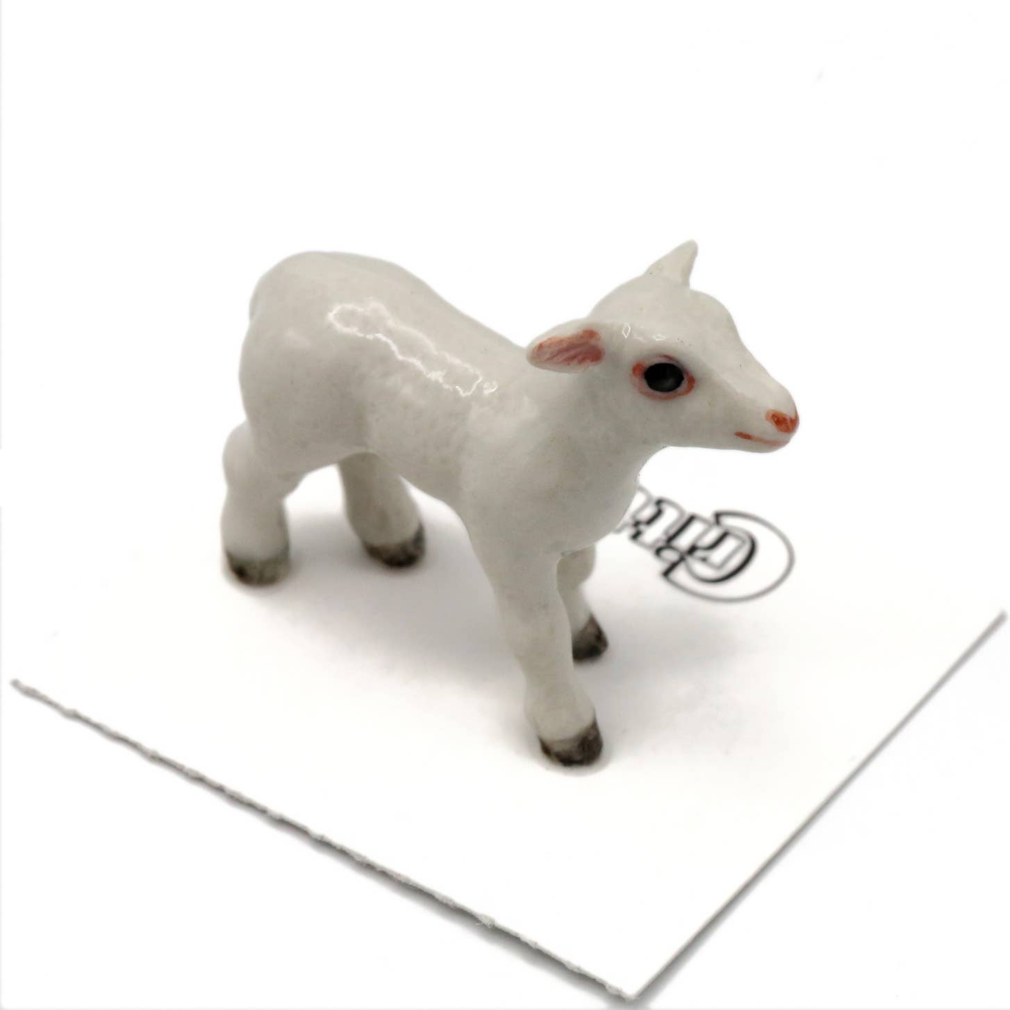 White ceramic lamb figurine on a white background