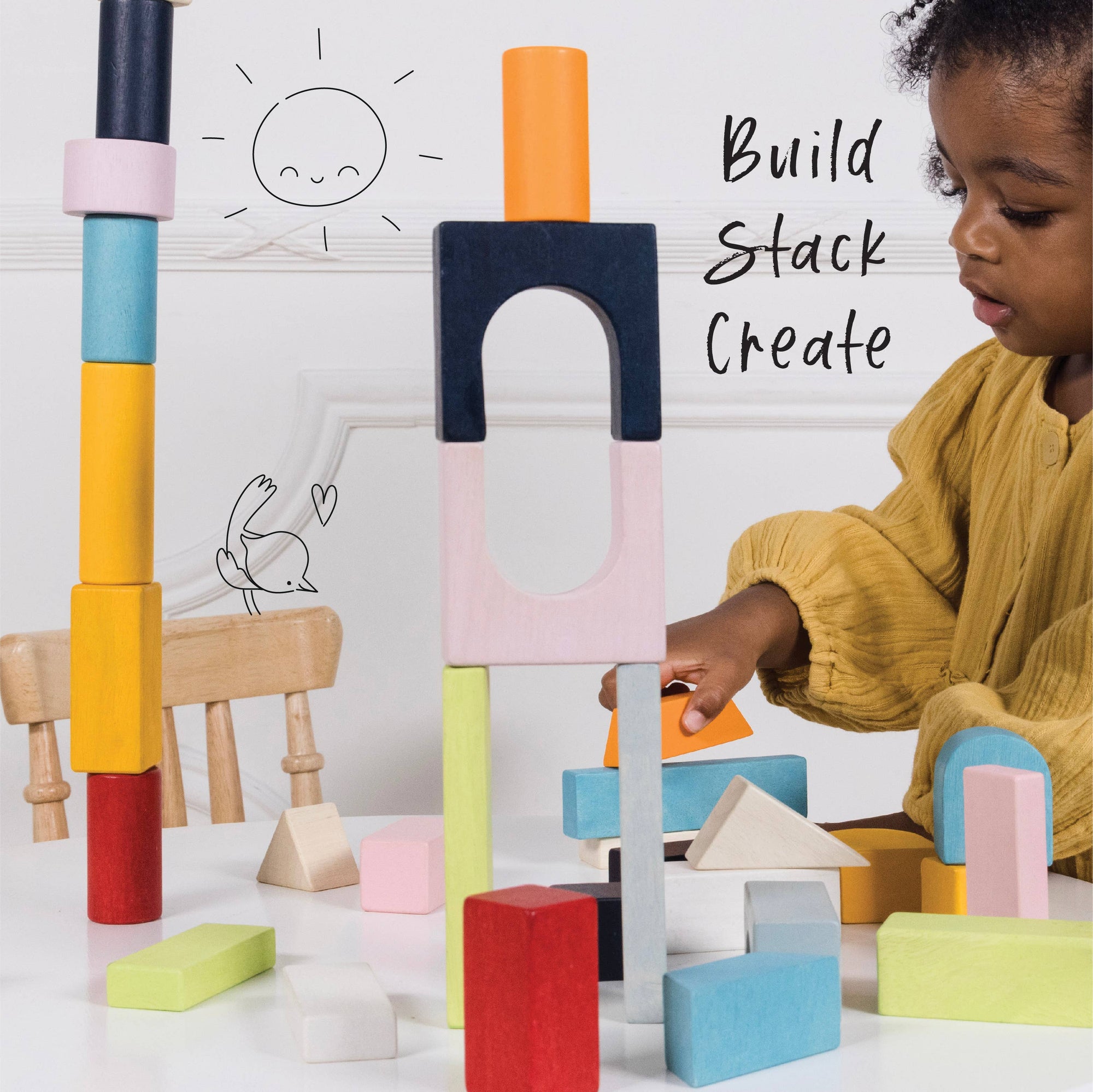 Child playing with colorful building blocks on a white surface with text 'Build Stack Create'.