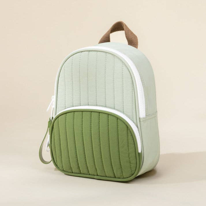 Green and white backpack on a beige background