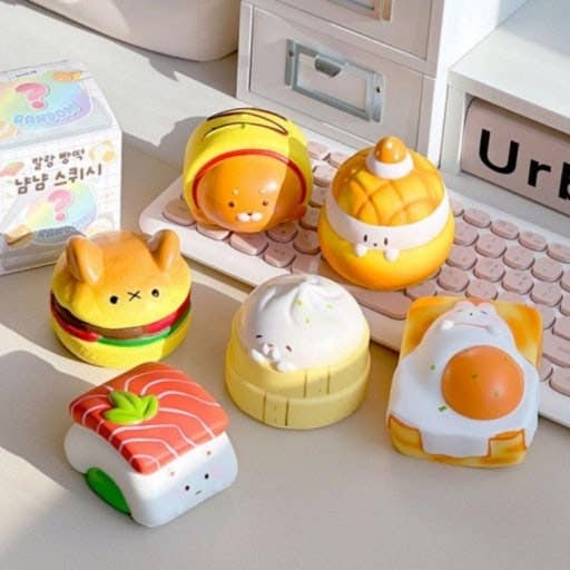 Set of cute food-themed toys on a desk with a keyboard in the background.